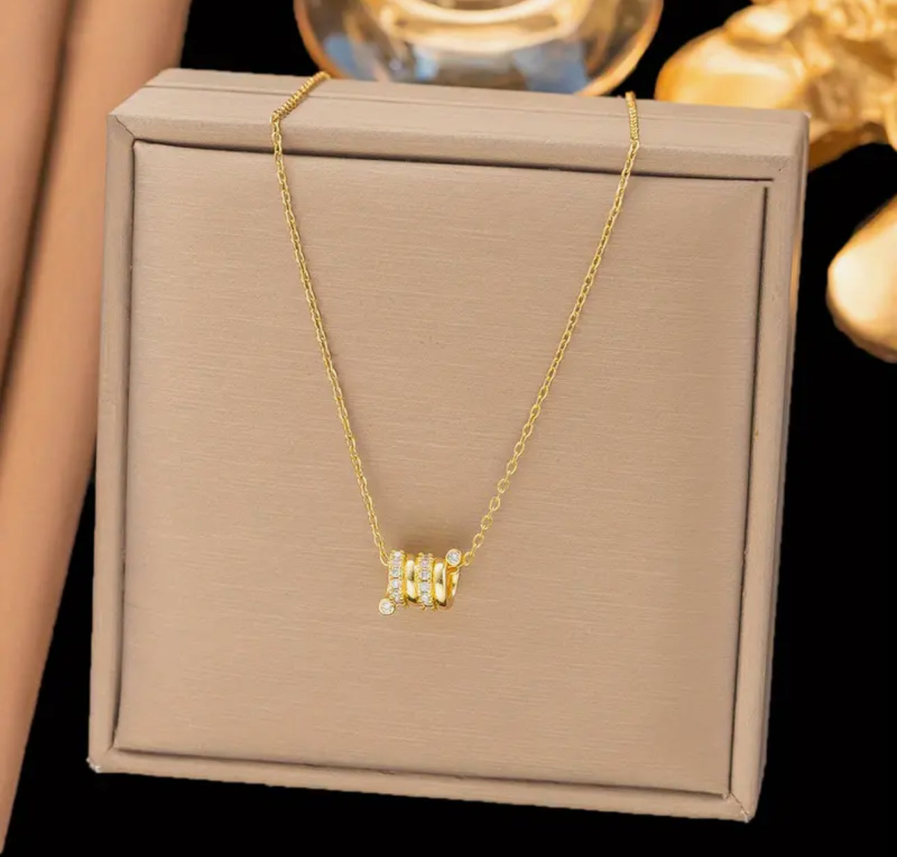 Elegant and modern, this delicate gold-toned necklace features three barrel-style pendants.