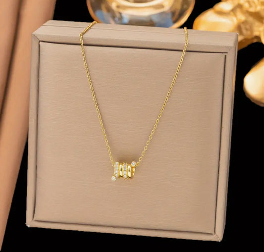 Elegant and modern, this delicate gold-toned necklace features three barrel-style pendants.