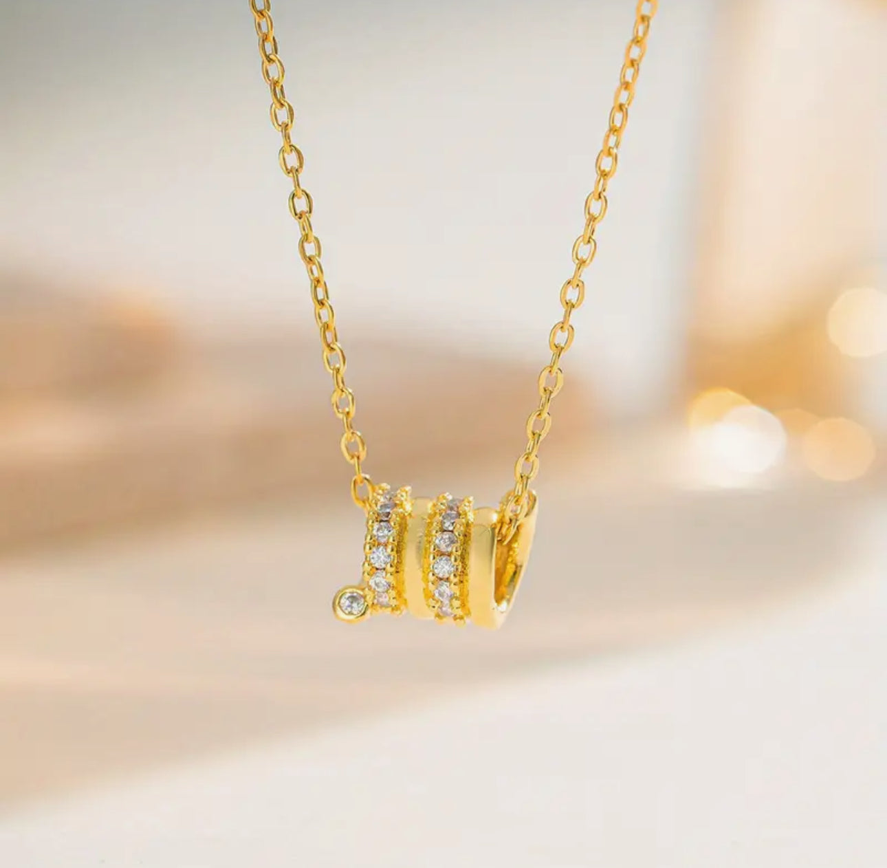 Elegant and modern, this delicate gold-toned necklace features three barrel-style pendants.